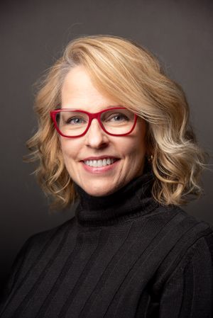 red glasses, headshot of woman with blonde hair, smiling