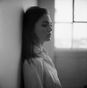 Ethereal black and white portrait with soft window lighting and classic profile pose.