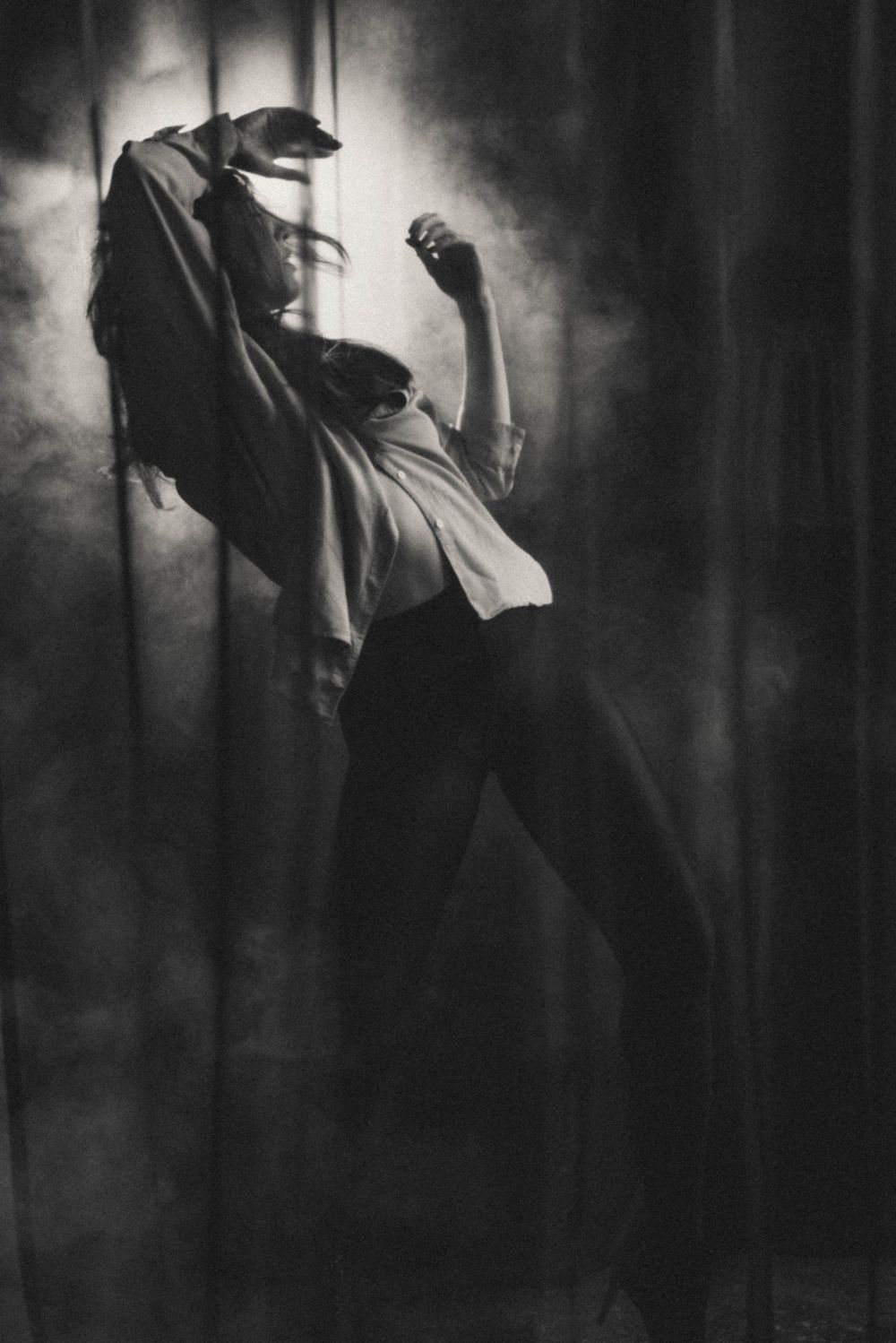 Dramatic black and white photograph showing silhouetted figure in motion.