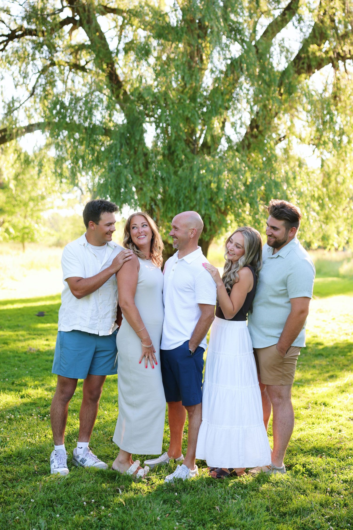 Family group standing together in winter scene with snow and evergreen trees in background.
