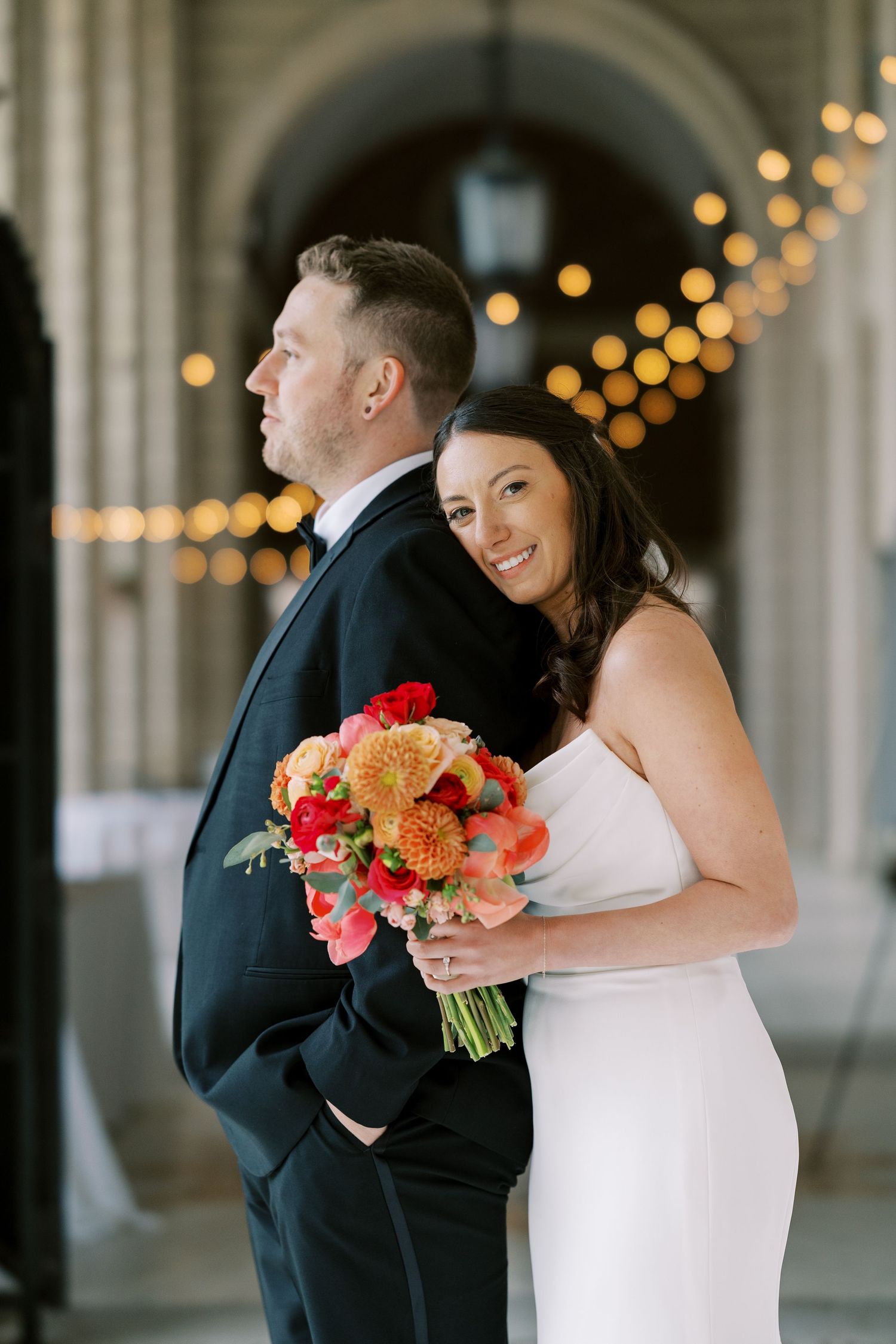 Elegant wedding couple sharing a romantic moment on grand stone steps by ornate iron gates at Hall of Springs.