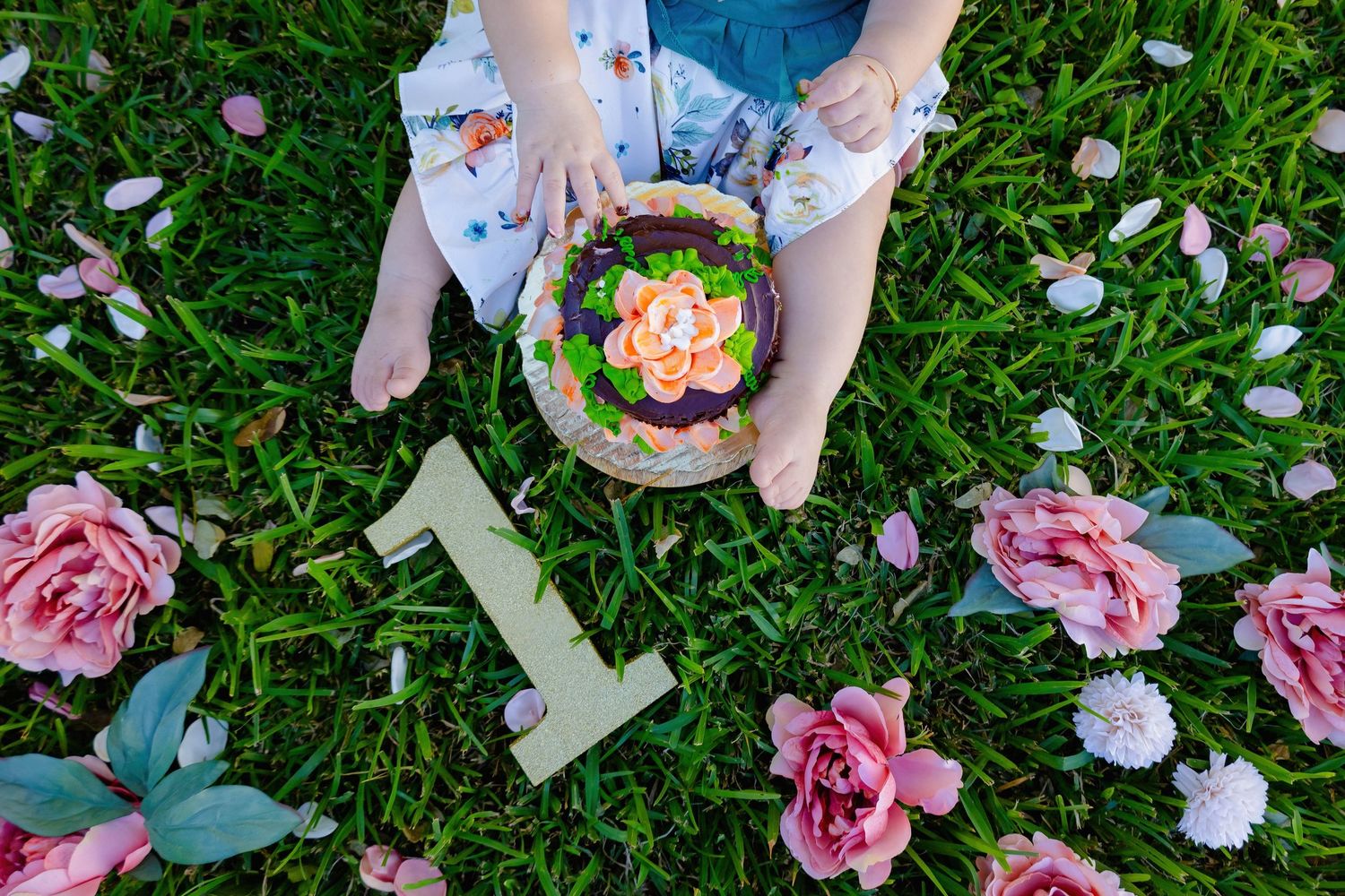Pink and white flower petals scattered across green grass create a romantic garden scene.