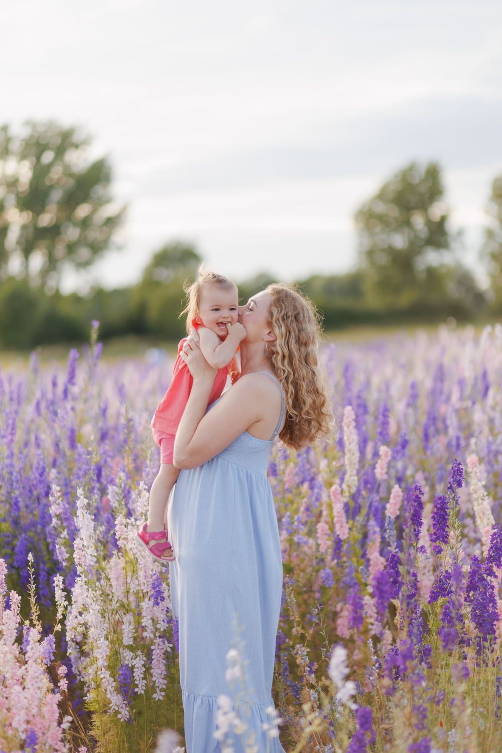 A tender moment in a vibrant field of purple and pink wildflowers on a summer evening.