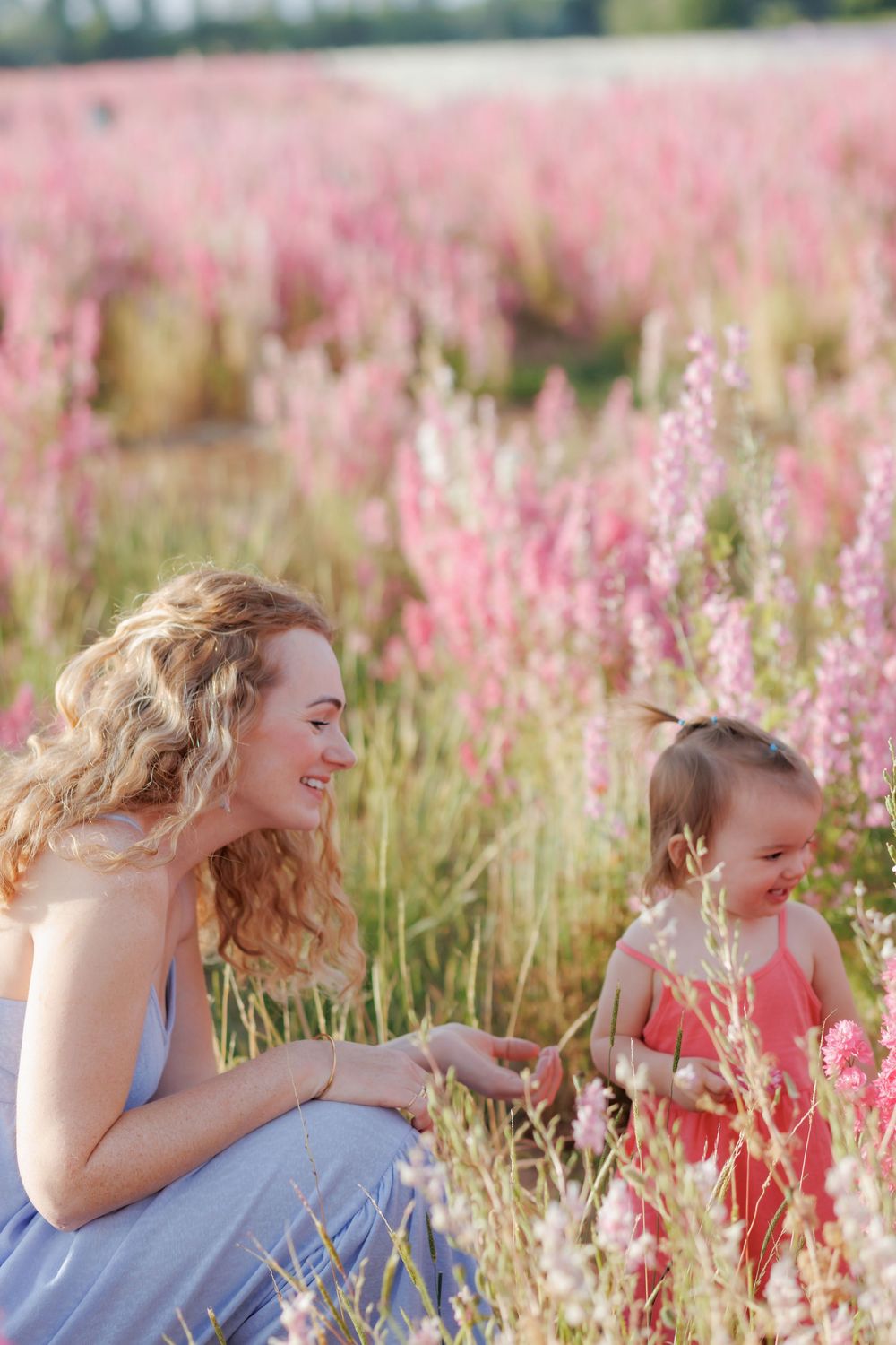 A joyful moment captured in a field of pink wildflowers on a sunny summer day.