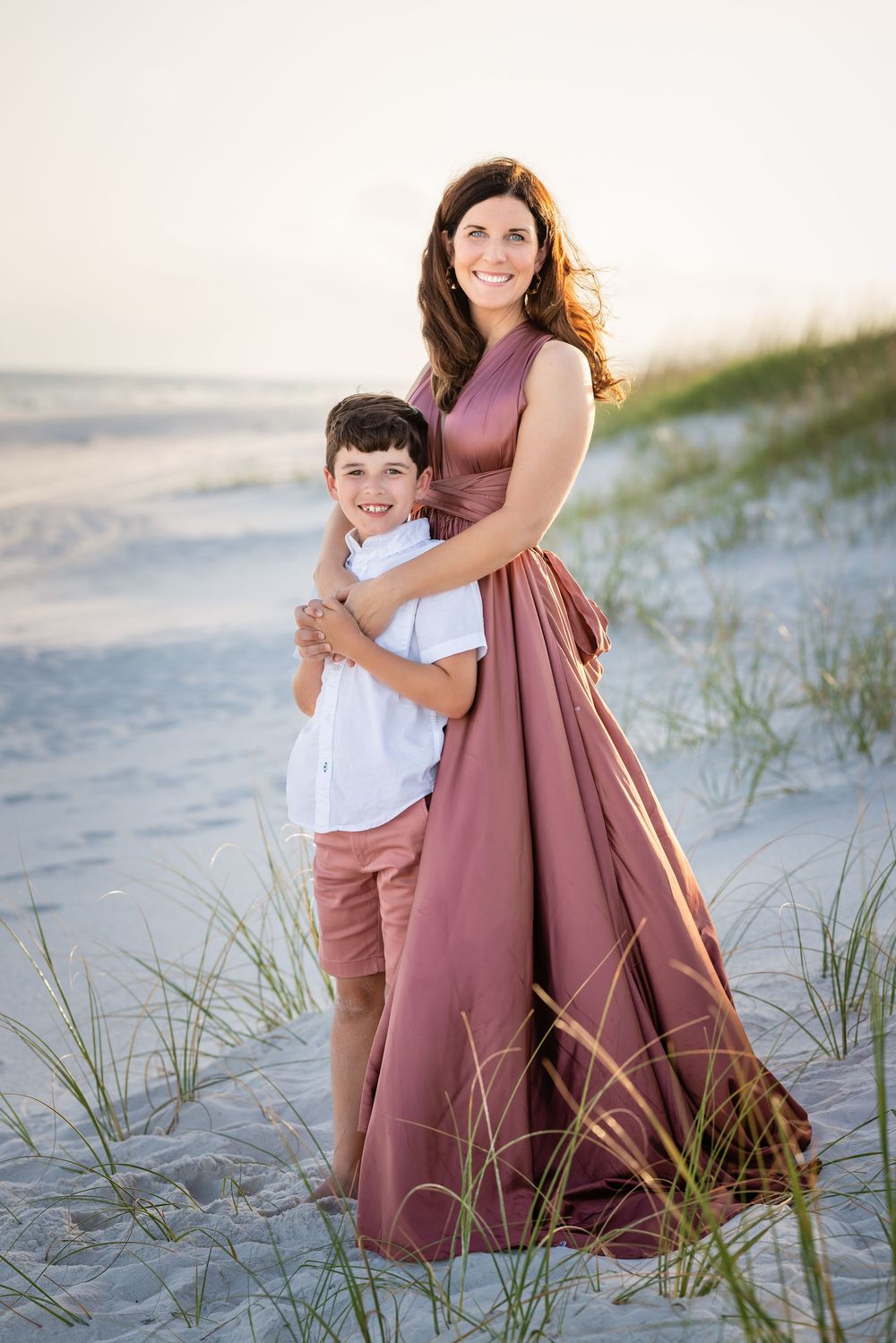 A collection of tender family moments captured on a sandy beach with dune grass at golden hour.