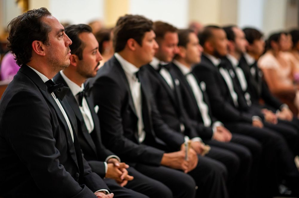 Row of formally dressed guests seated during an elegant event ceremony.