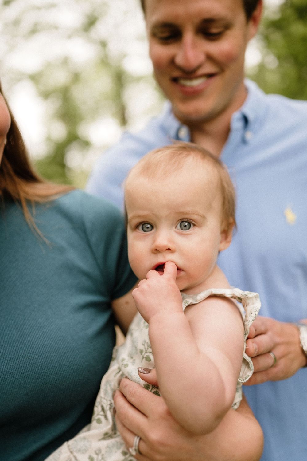 An intimate family portrait outdoors with soft natural lighting.