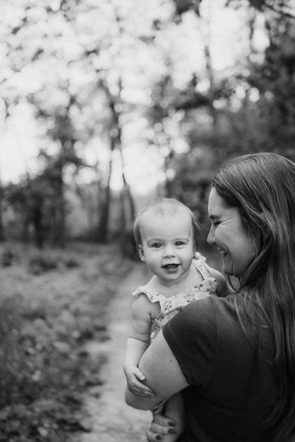 A sweet black and white candid moment between parent and child outdoors.