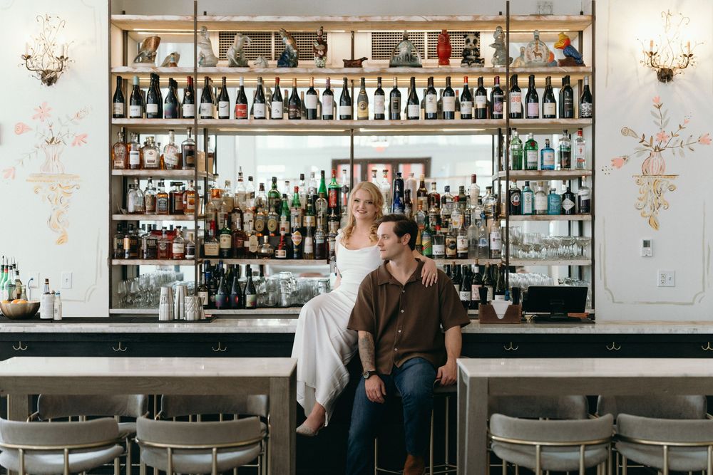 A bar interior with extensive liquor bottle display and elegant decor featuring multiple seating areas.