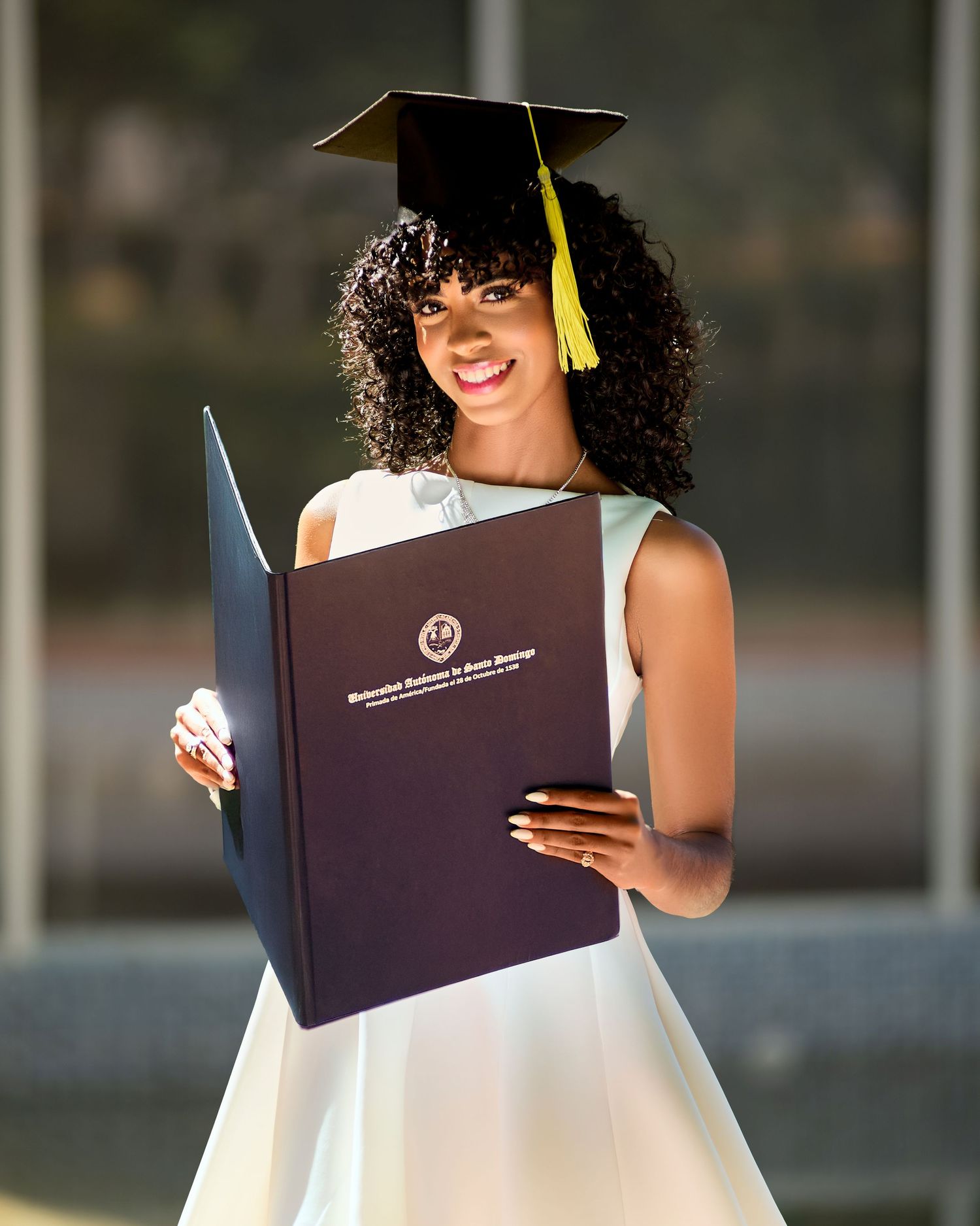 Sesión fotográfica de graduación UASD con toga y birrete, fotos creativas y profesionales en estudio o exteriores en República Dominicana.