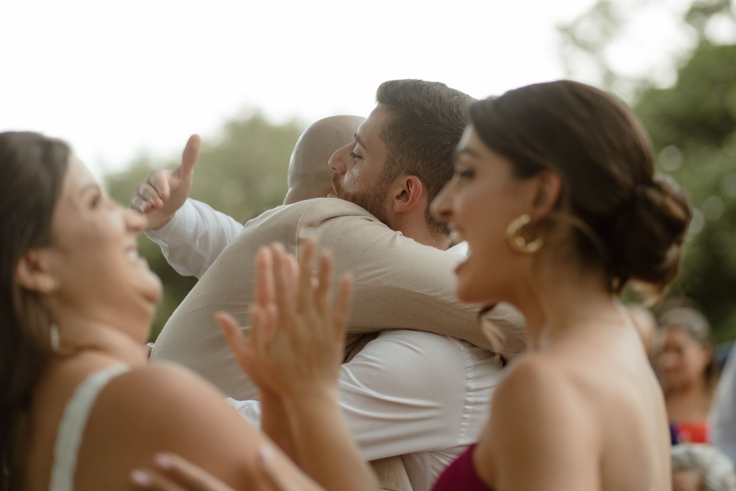 Joyful wedding celebration moment with guests clapping in background.