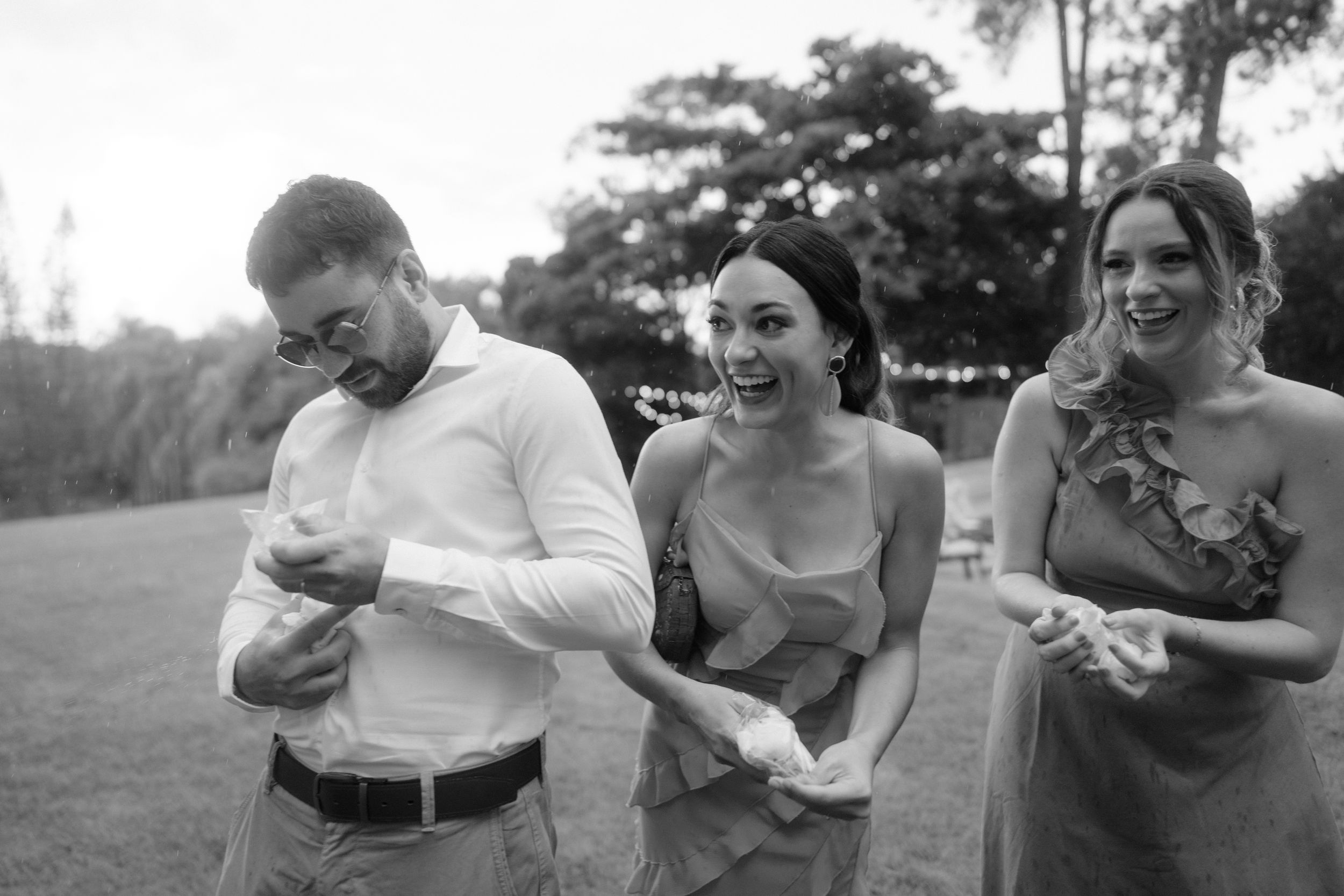 Wedding party having fun and laughing together outdoors on a sunny day.