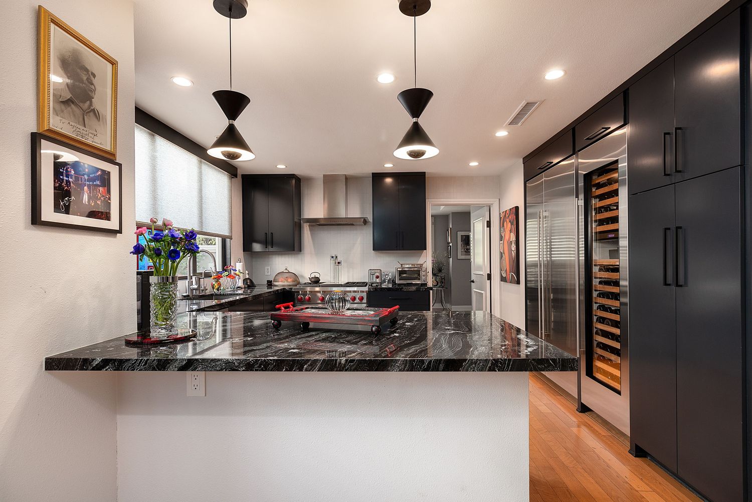 Modern kitchen with dark cabinets, stainless steel appliances, and recessed lighting showcases sleek contemporary design.