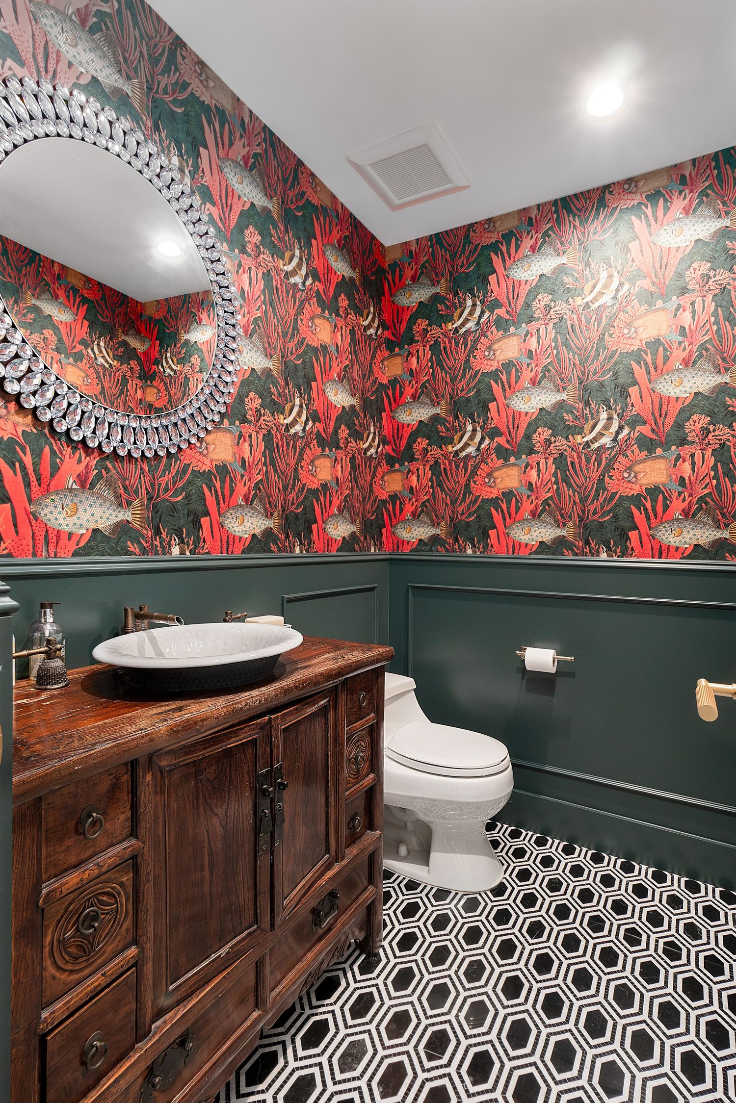 Stylish powder room featuring bold floral wallpaper, dark wood vanity, and geometric floor tiles.