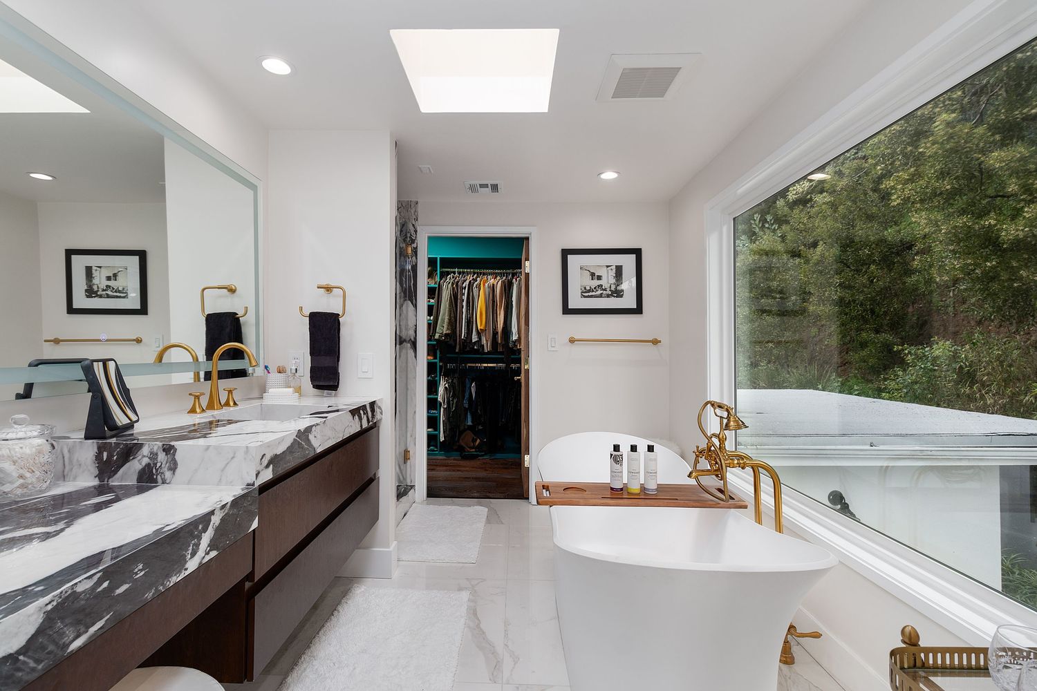 Contemporary white kitchen with skylight, minimalist design, and sleek countertops.