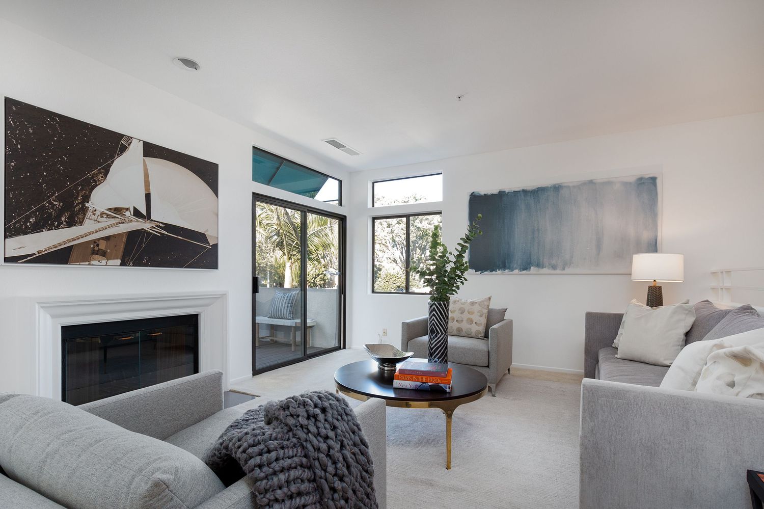 Minimalist living space with modern furniture, gray sofa, and large windows providing natural light.
