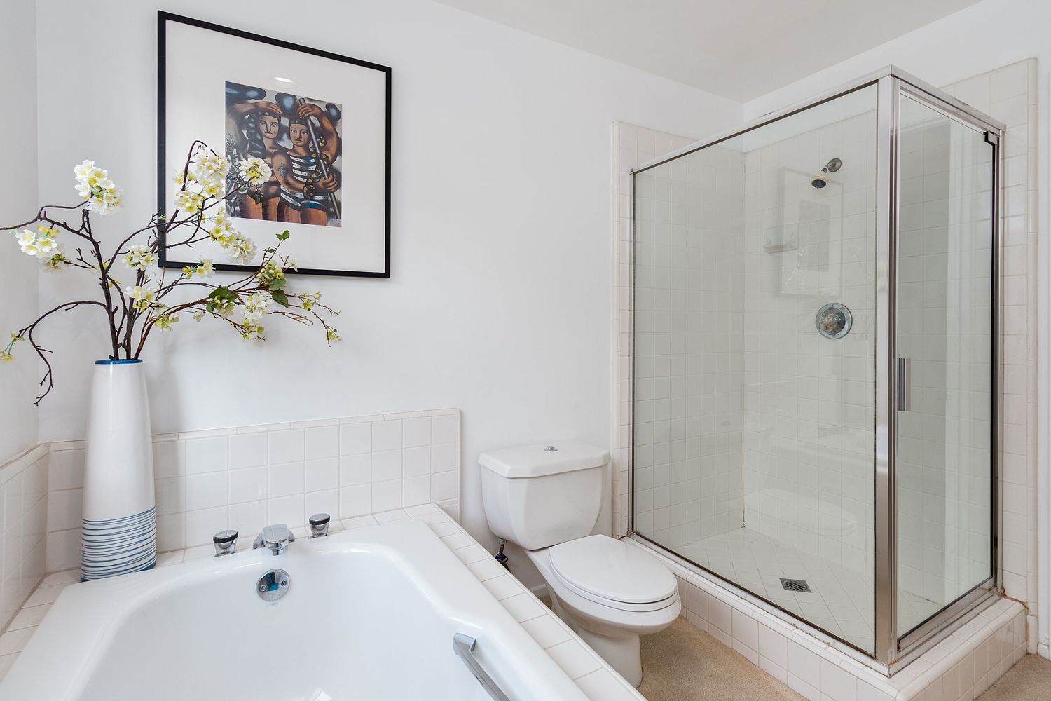 Modern bathroom featuring glass shower enclosure, white tiles, and contemporary fixtures.