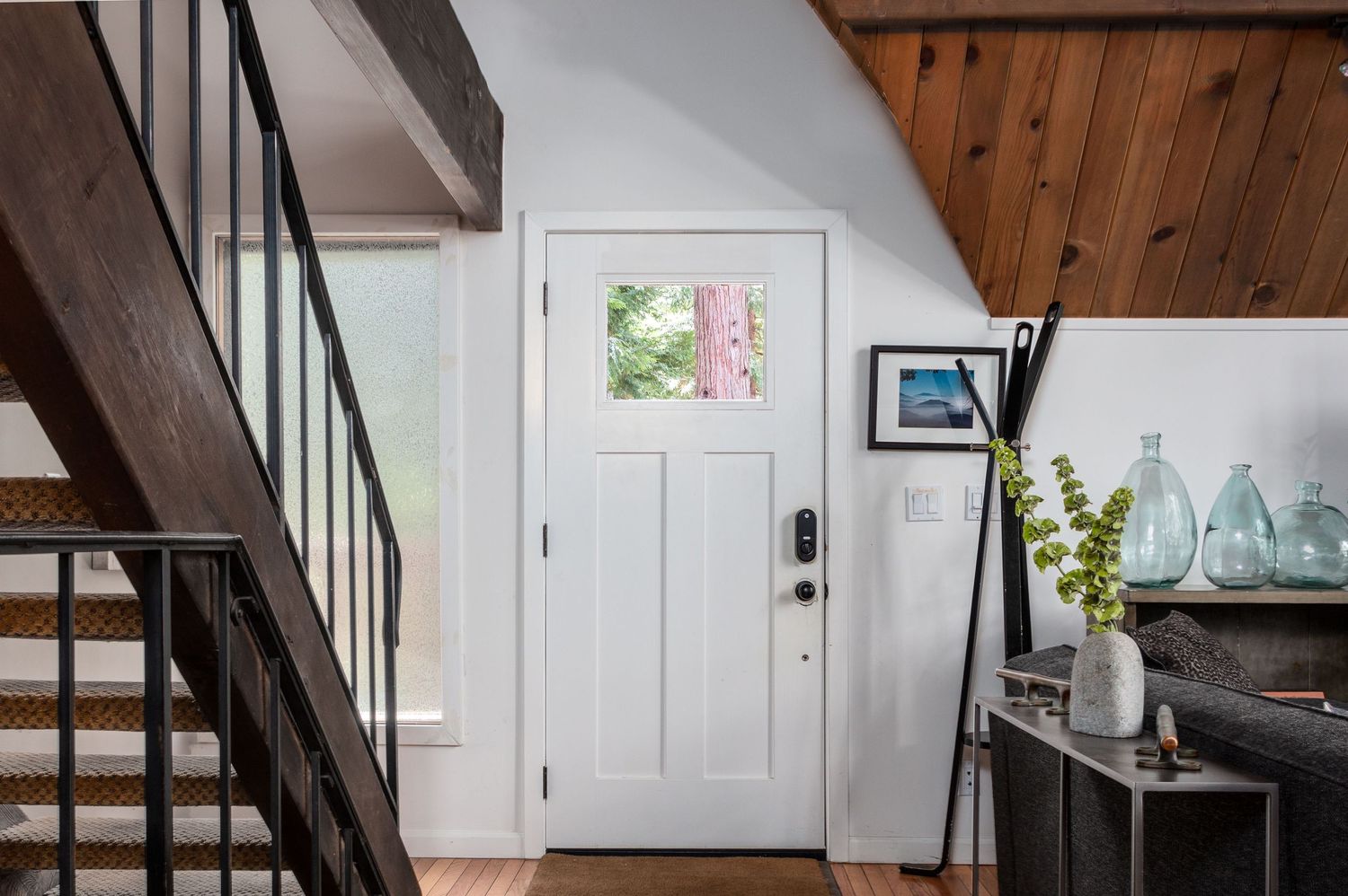 Modern A-frame interior with wooden beams, white walls, and contemporary furnishings.