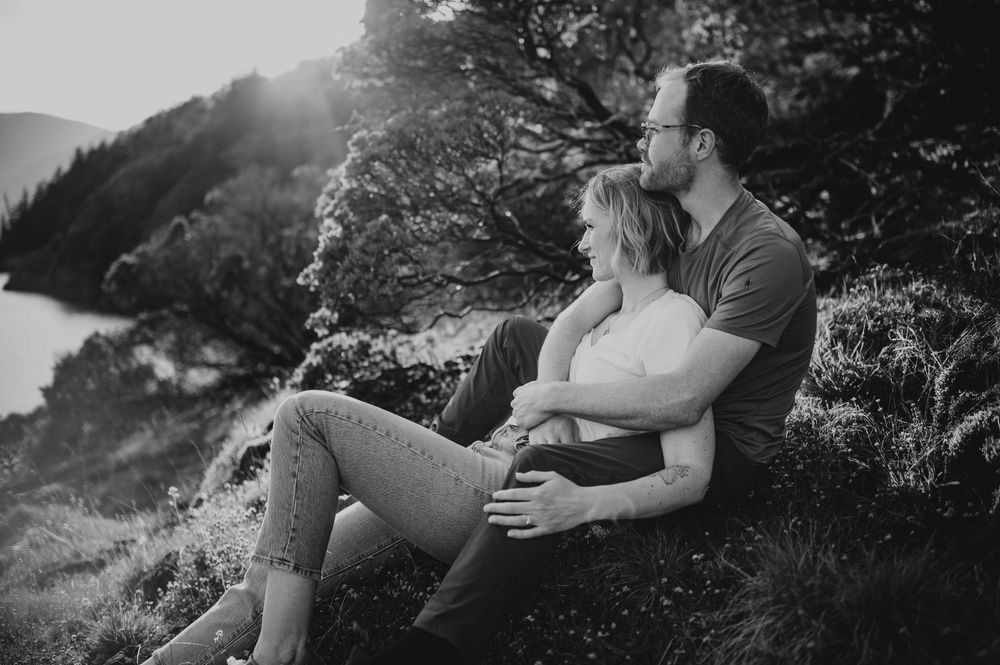 Beautiful photoshoot of engaged couple sitting with each other on Comox Lake bluffs during golden hour in Courtenay Vancouver Island