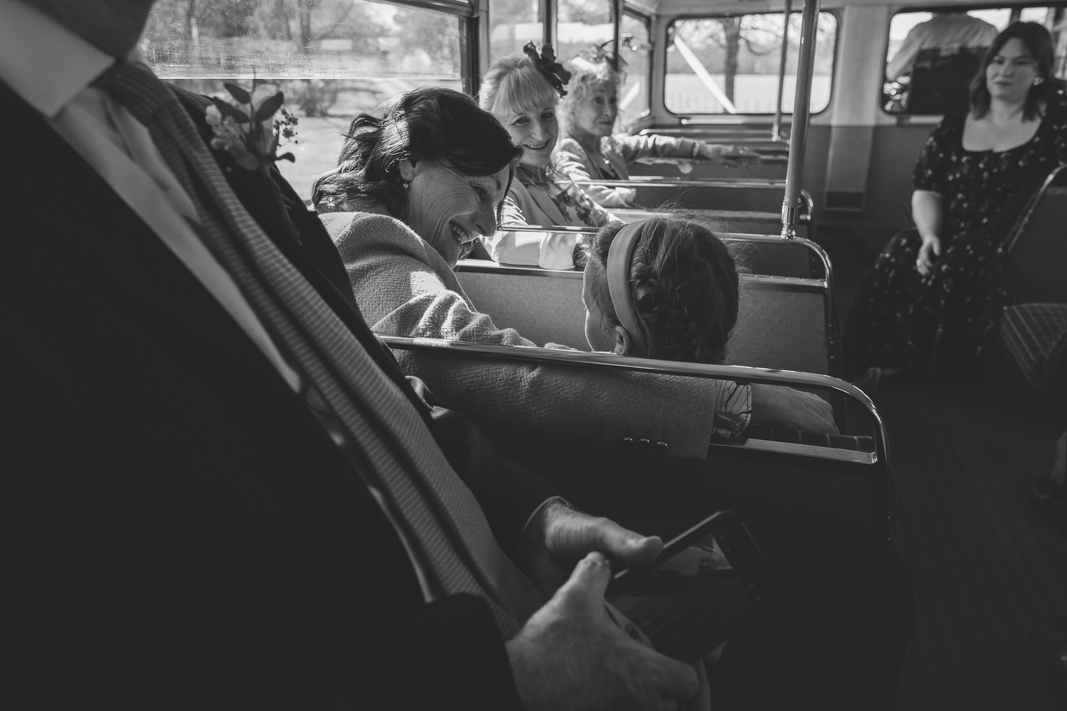 Passengers sit in seats aboard a vintage bus in black and white photograph showing 1950s era public transportation.