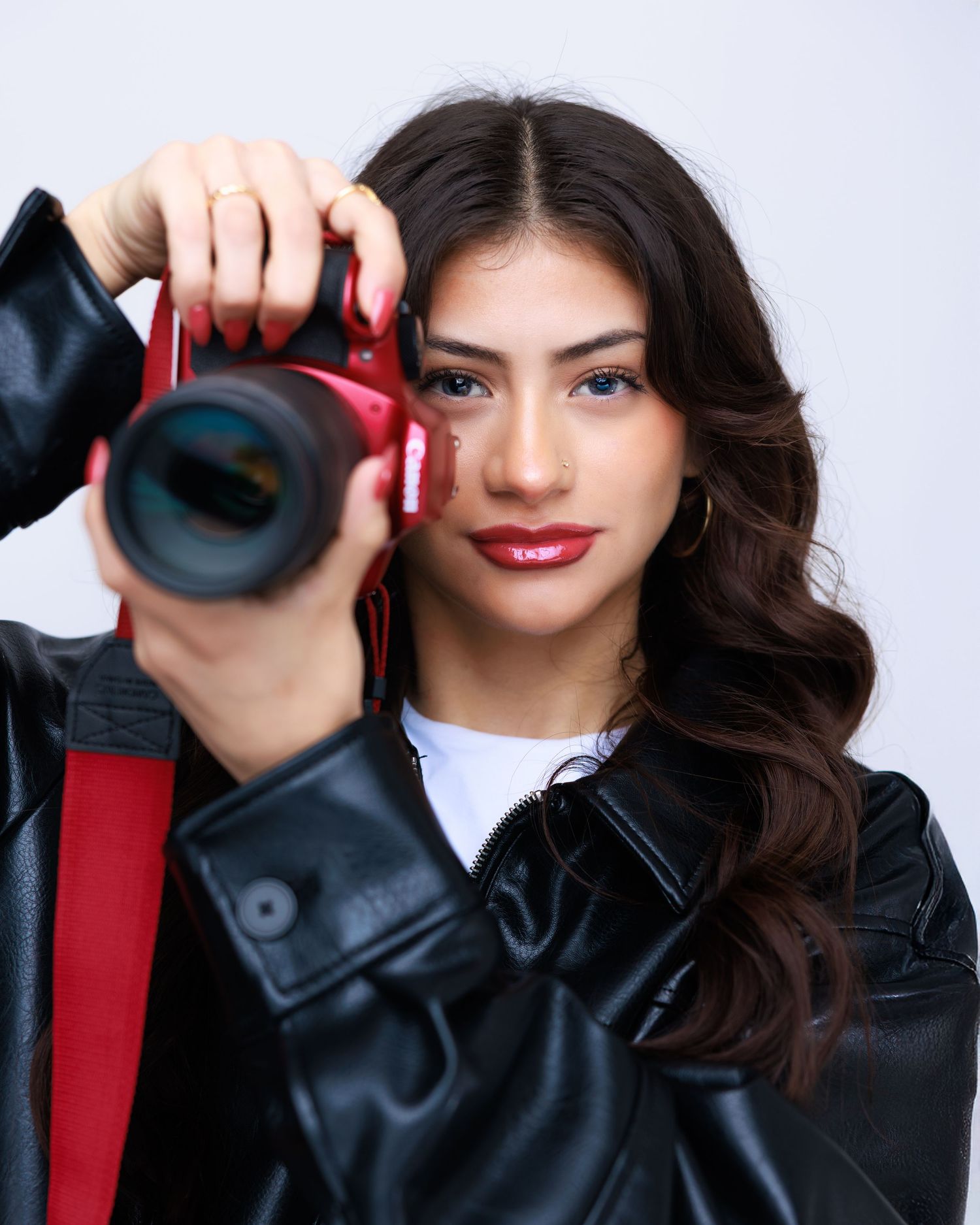 Fashion portraits featuring dark hair and leather jacket with red accessories.