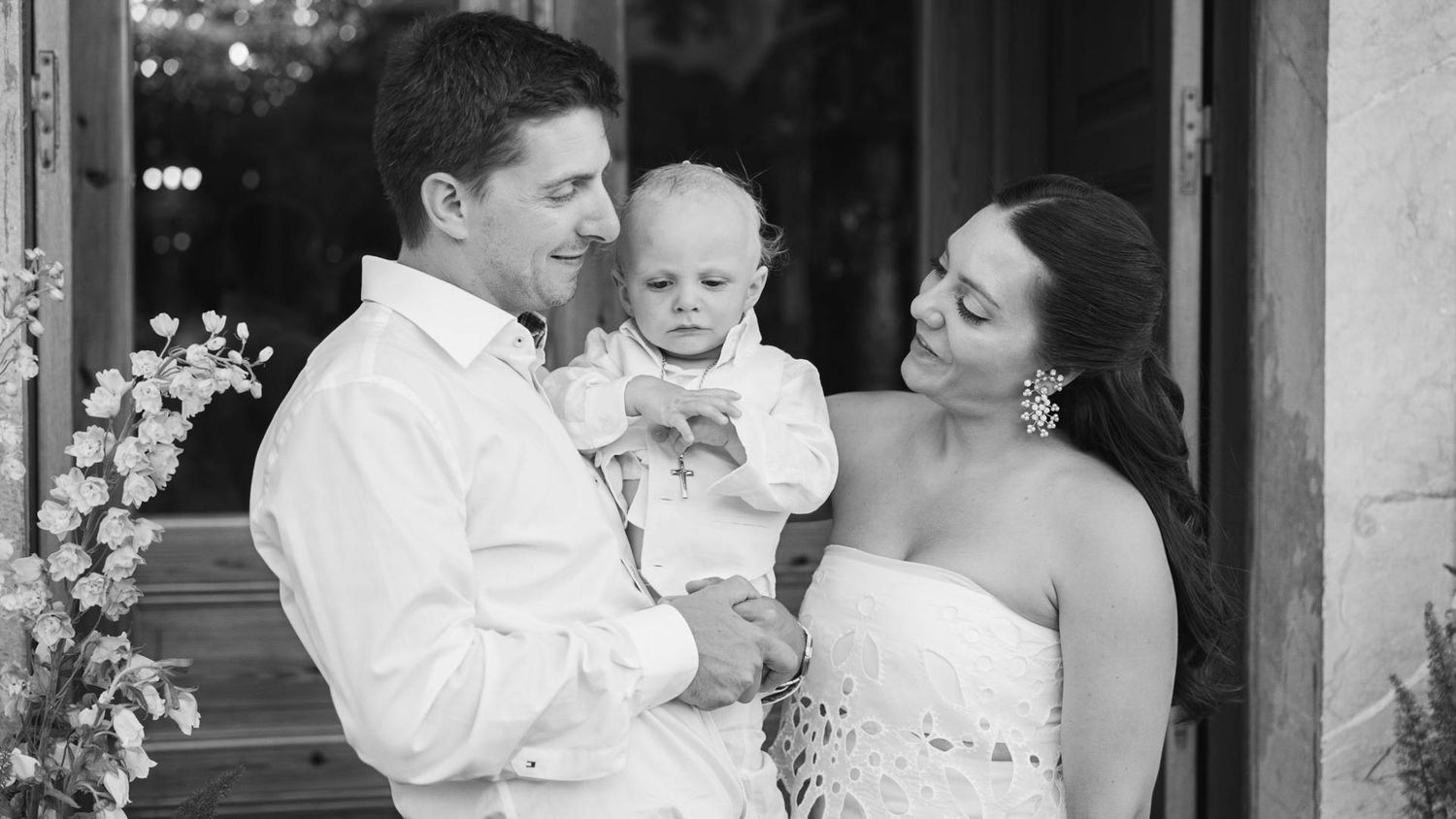 A loving family shares an intimate black and white moment on their wedding day with their baby.