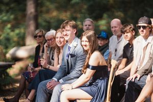 Group of guests sitting outdoors in casual attire at a sunny summer gathering.