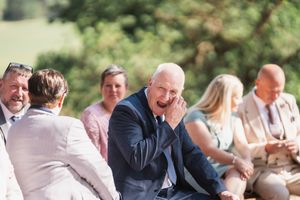 Wedding guests share laughter and conversation during an outdoor reception.