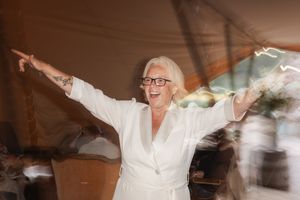 Person wearing a white bathrobe stands with arms outstretched in joyful celebration during morning preparations.