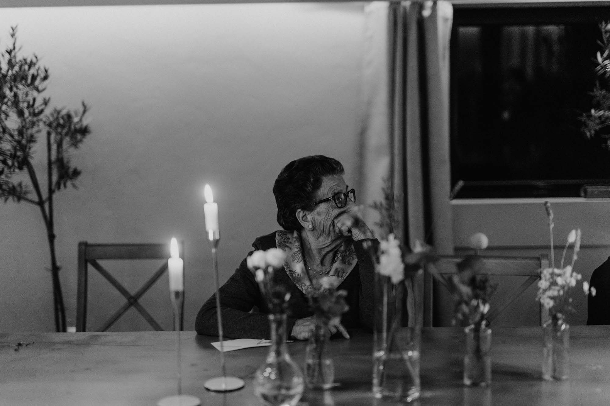 A black and white photograph of a candlelit dining table at Quinta da Eira - Documentary wedding photography