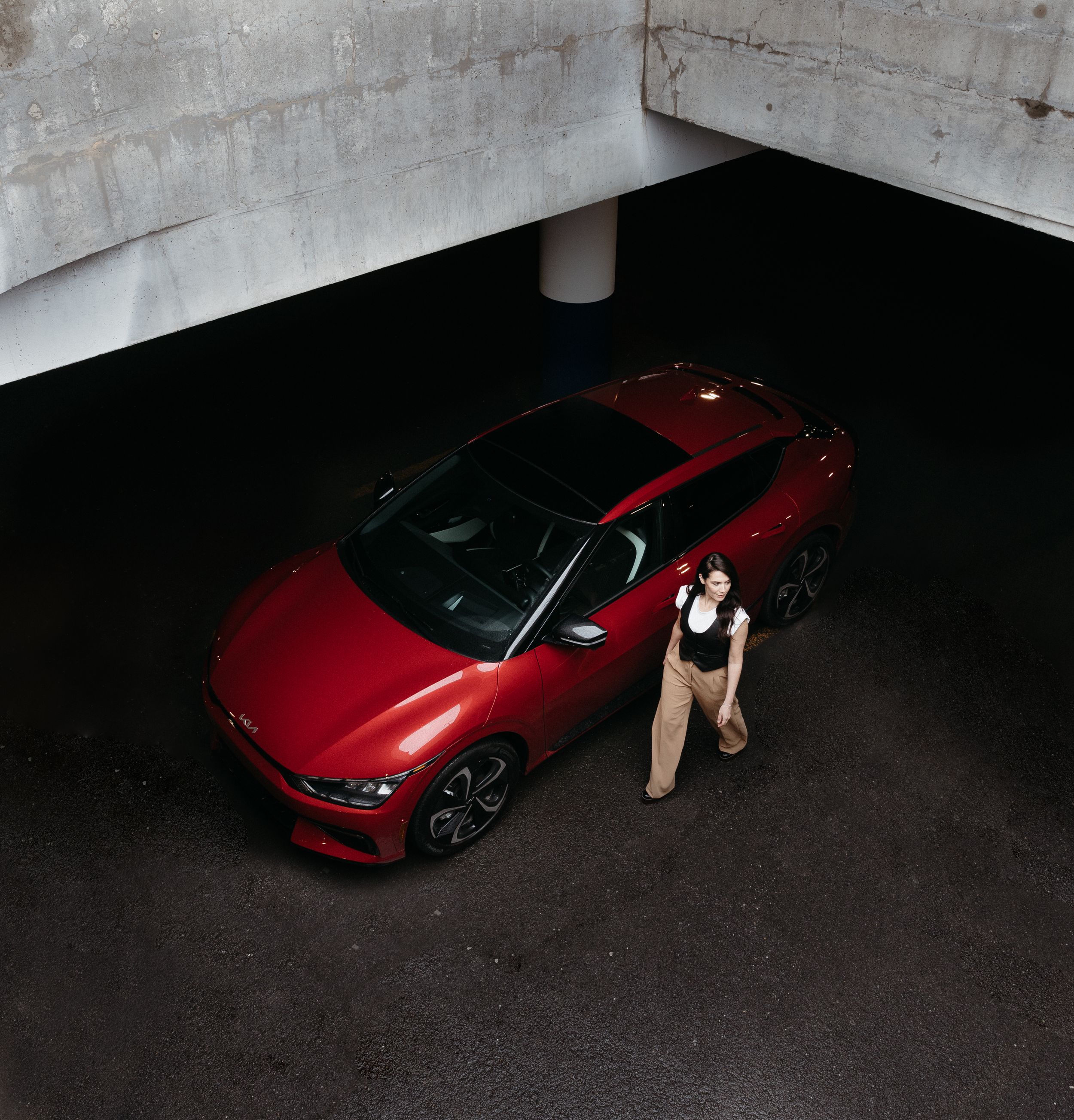 A red Corvette C8 sports car moves through a dimly lit parking garage in a sequence of progressive frames.