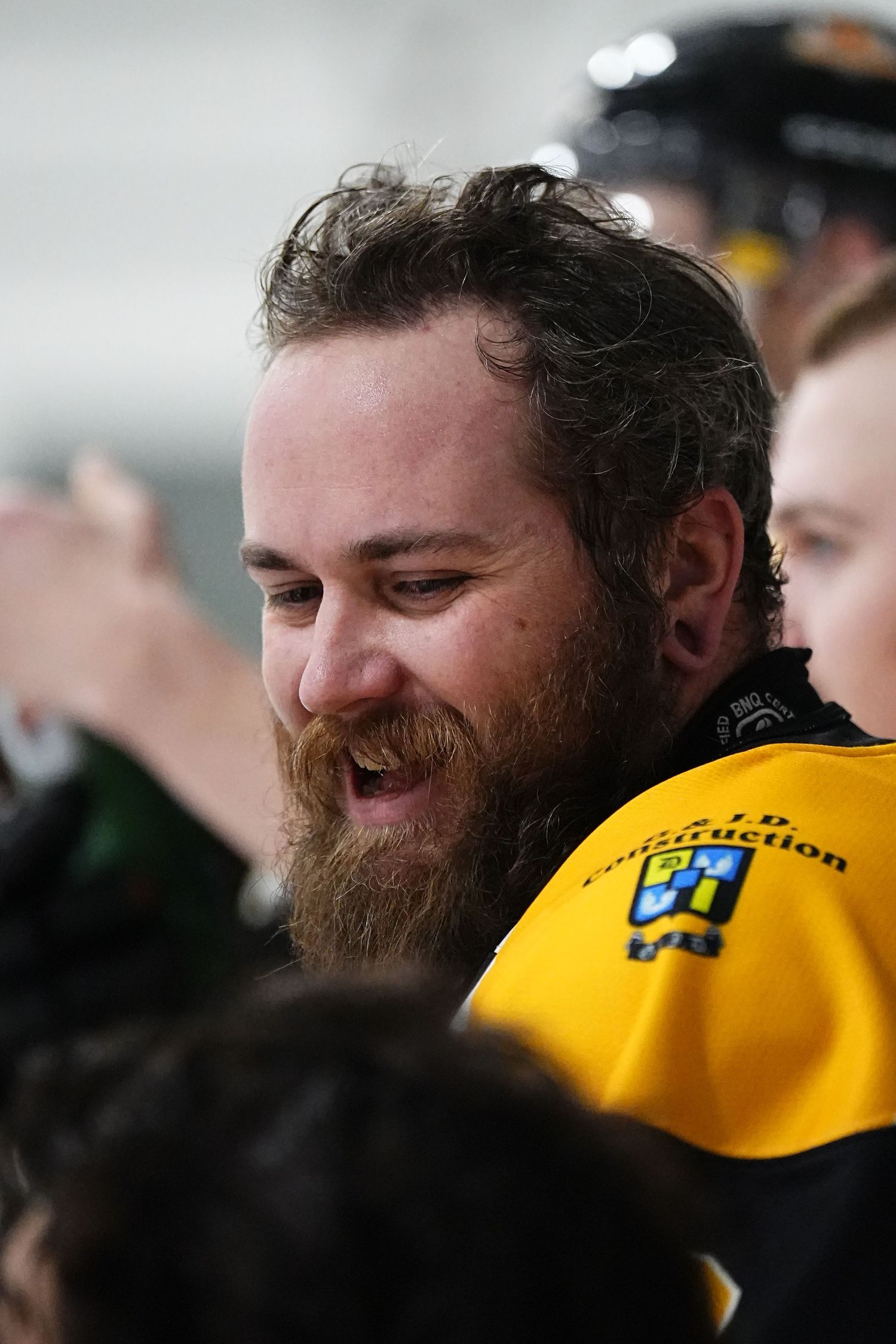 Sports fan in yellow jersey celebrating with enthusiastic expression.