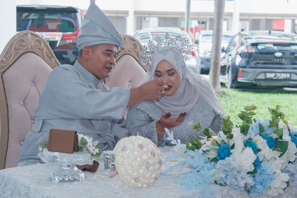 A couple sharing a tender moment during their wedding reception with blue and white decorations.