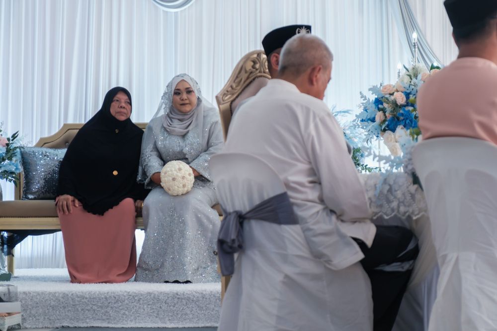 Wedding guests and celebrants gathered around decorated tables at a traditional ceremony.