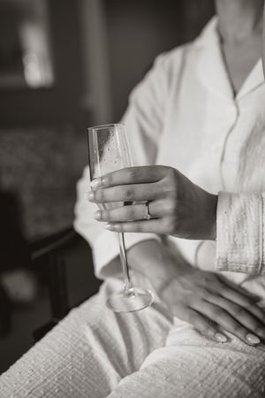 Black and white photo series showing hands holding a glass in a white dress setting.