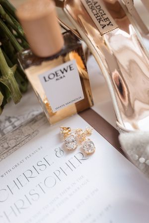 Wedding perfume bottles and accessories arranged on a white surface with elegant typography.