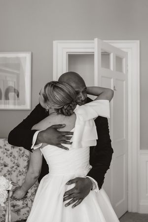Joyful embrace captured during an intimate wedding first look moment.