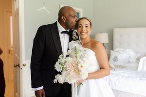 A joyful wedding moment captured with the couple sharing an intimate moment with a beautiful white bouquet.