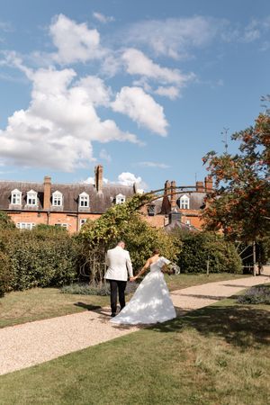 Wedding celebration on a gravel path with historic brick buildings in the background.