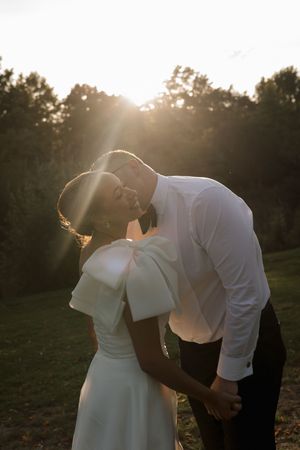 Romantic sunset silhouettes of a couple sharing intimate moments in their wedding attire.