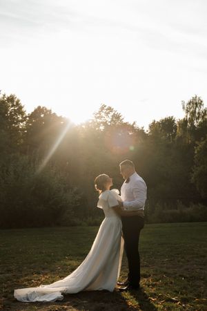 Wedding photos captured at sunset with golden light streaming through trees in a park setting.
