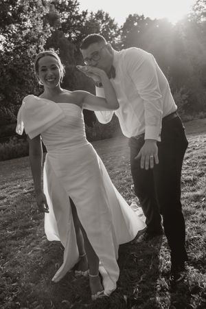 Black and white candid shots of wedding party dancing and celebrating outdoors at sunset.