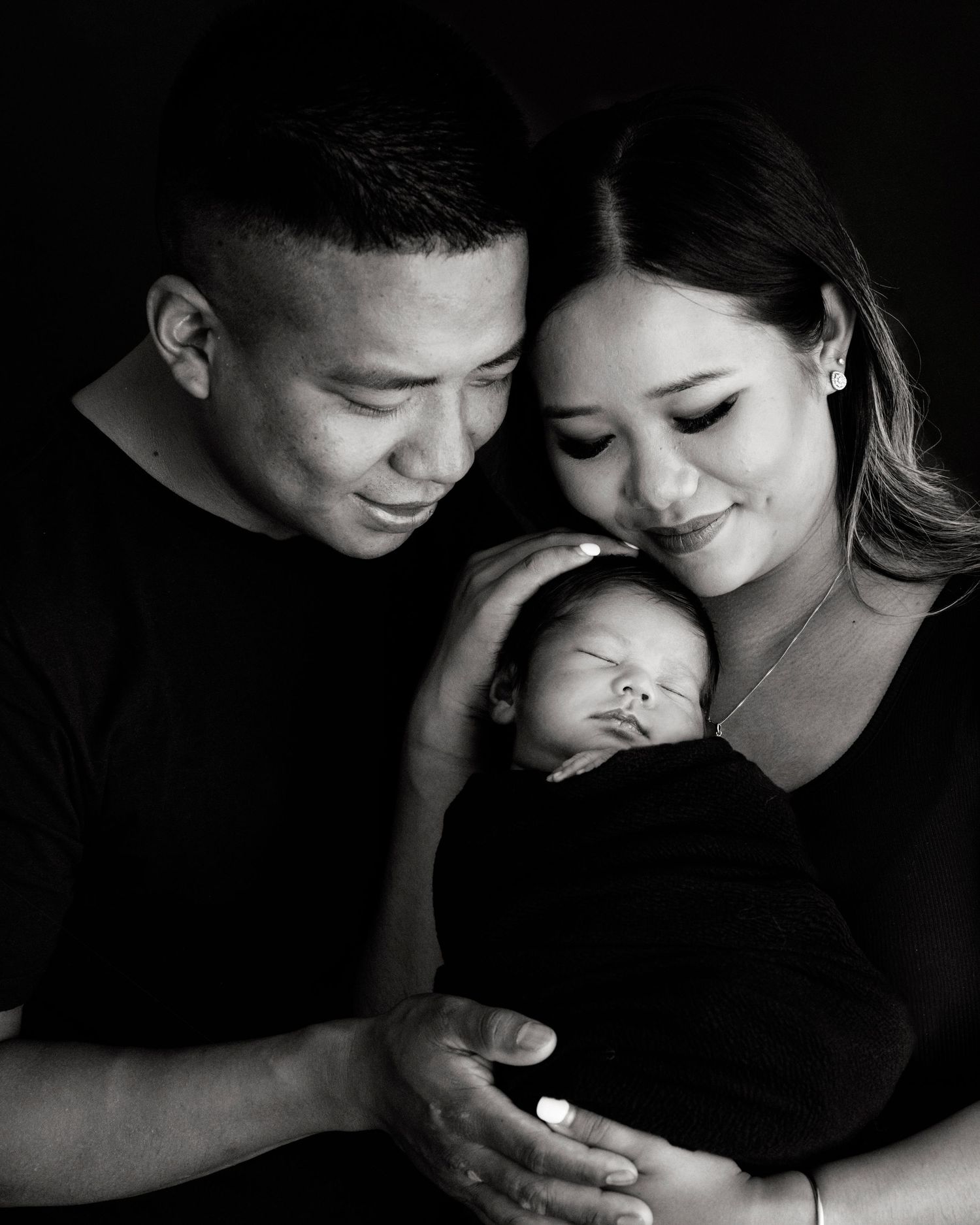 A series of intimate black and white photos showing tender moments between new parents and their newborn baby boy.