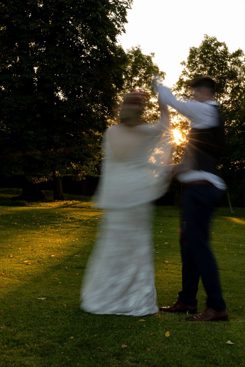 Silhouette of a dancing couple at sunset with sunlight bursting through their movement.