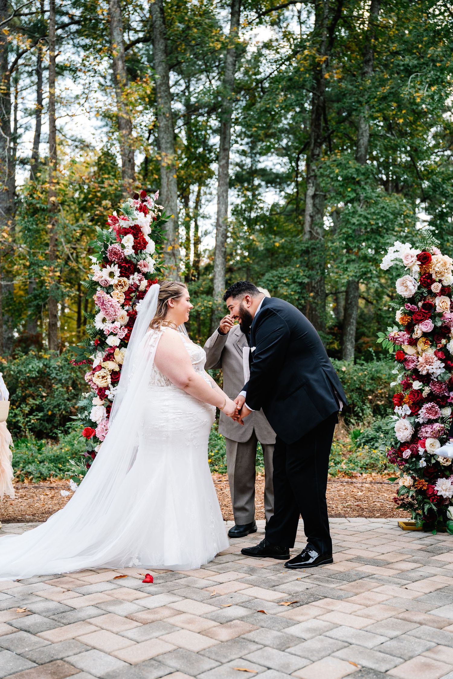 Brides sharing a sweet moment holding hands during a golden hour wedding ceremony outside the Weymouth Center Southern Pines, NC.