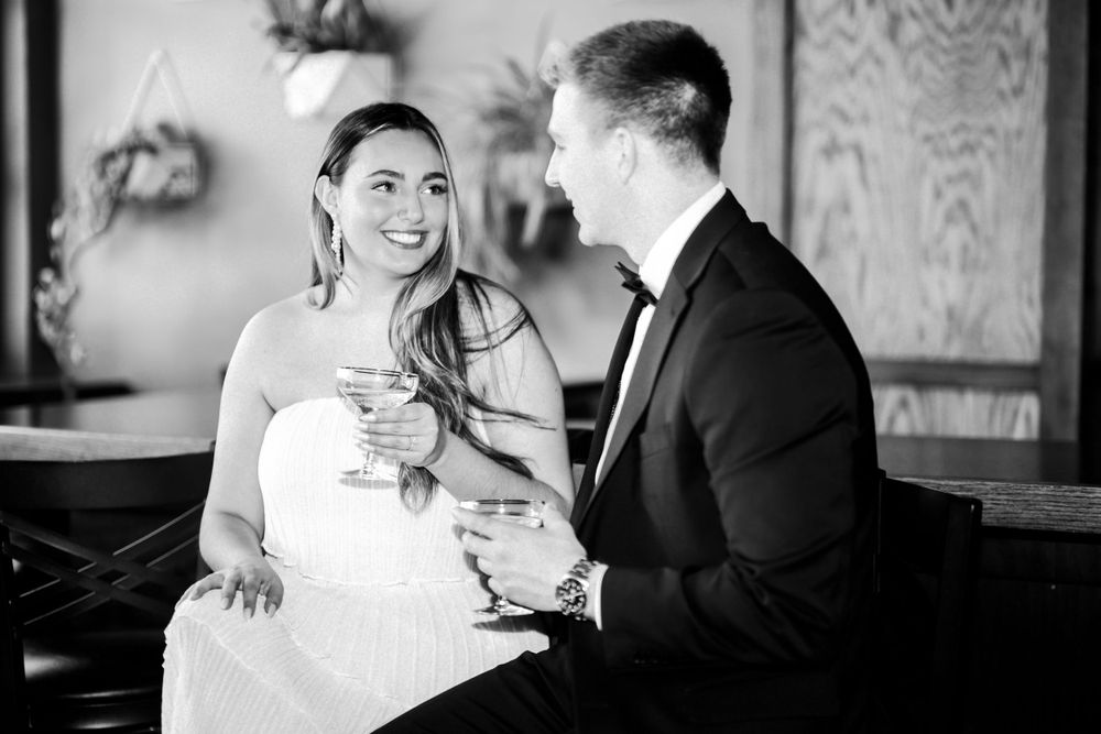 A tender black and white wedding moment between a couple seated at a piano.