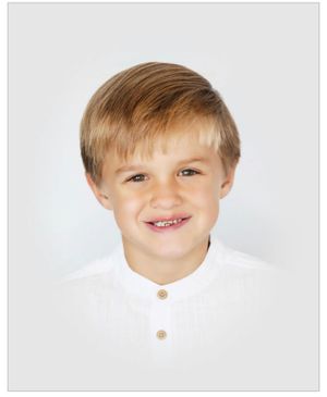 Professional headshot of child with casual white henley shirt against light background.