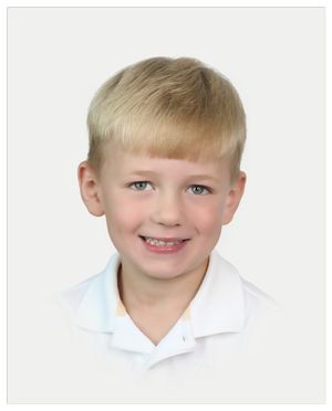 School photo of child in white polo shirt against neutral background.