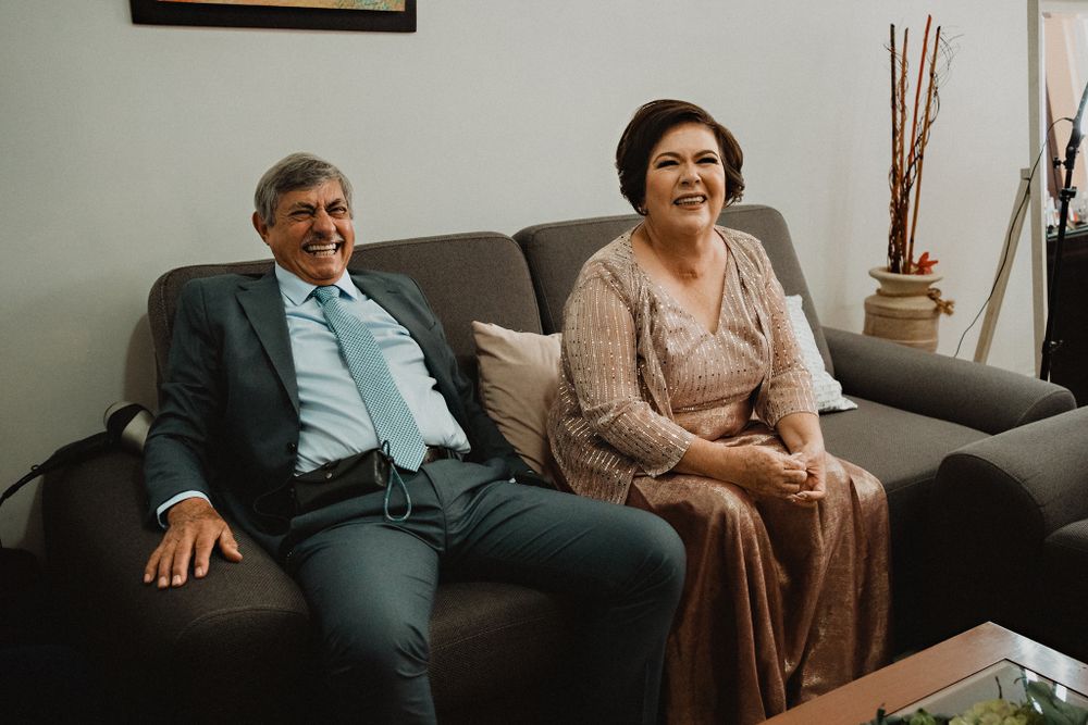 Foto 4: Happy parents watching their daughter (the bride) in her wedding dress, a heartwarming moment of pride and joy