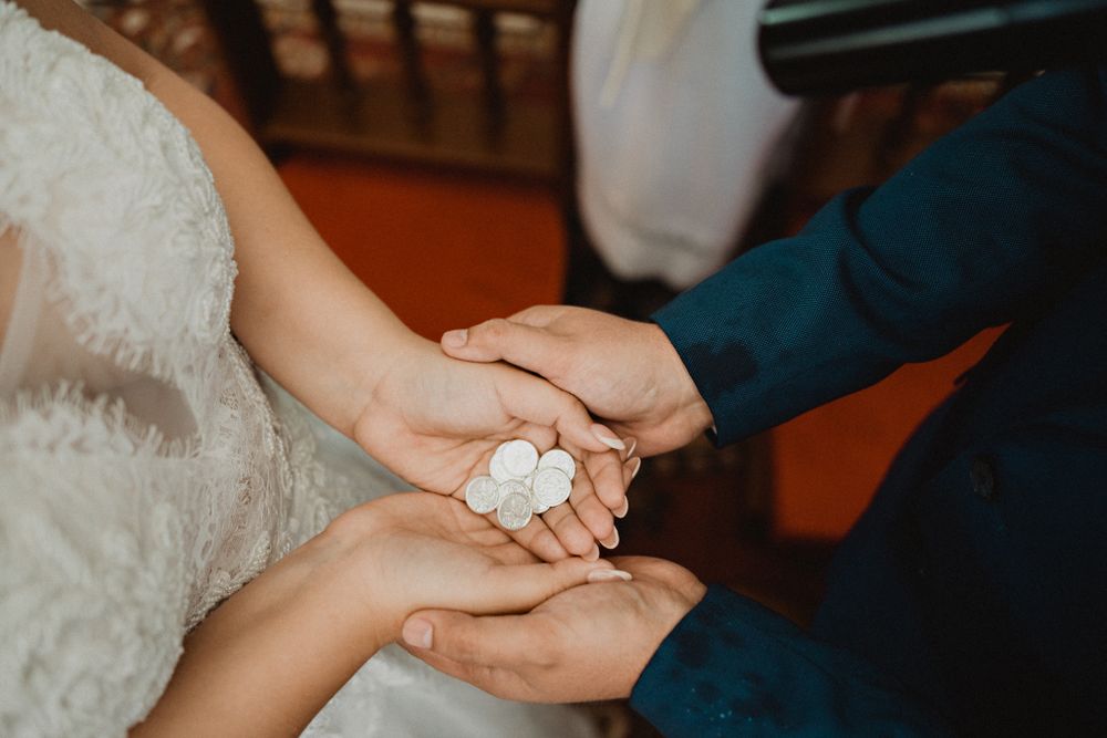 Couple holding the wedding coins (arras), symbolizing their unity and commitment to each other